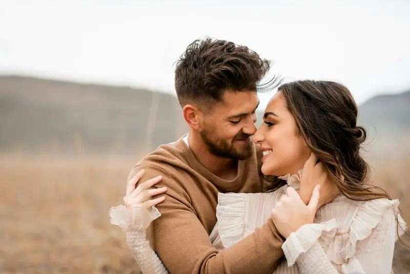 Engaged couple embracing and smiling at each other